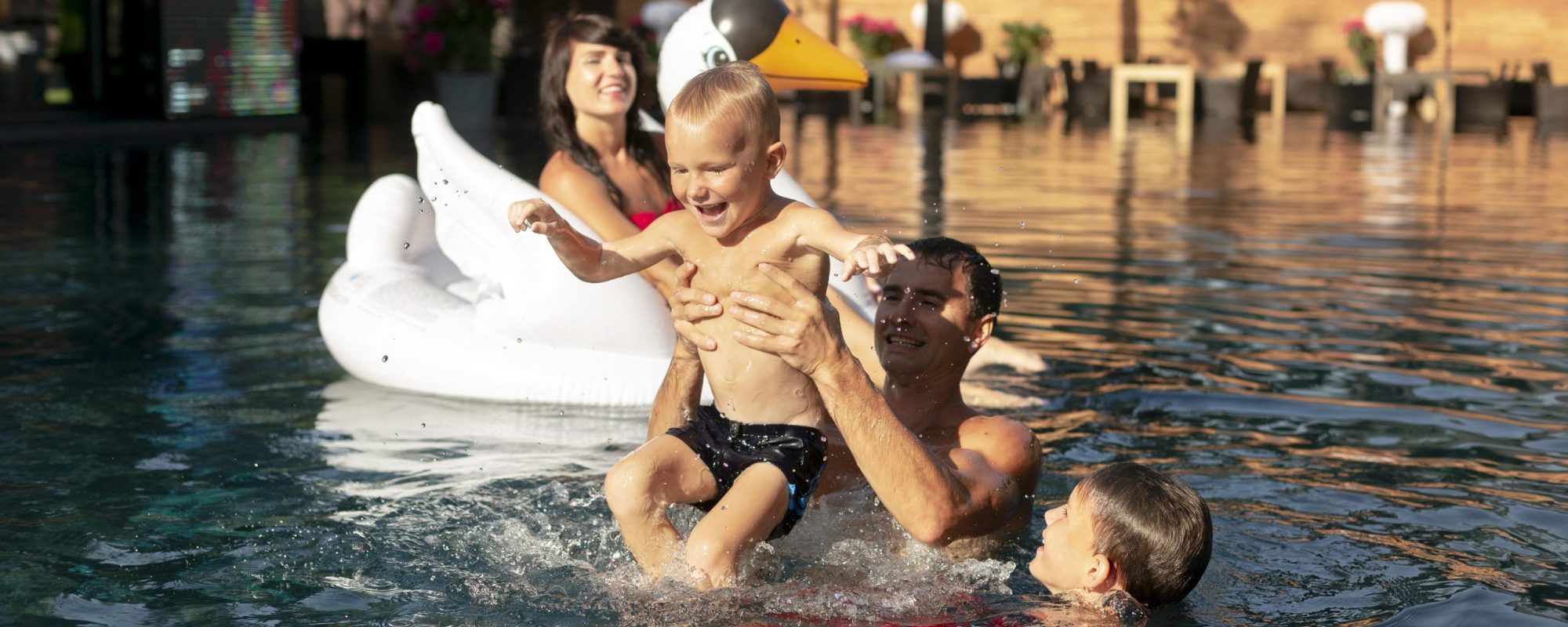 family-four-enjoying-day-swimming-pool-together