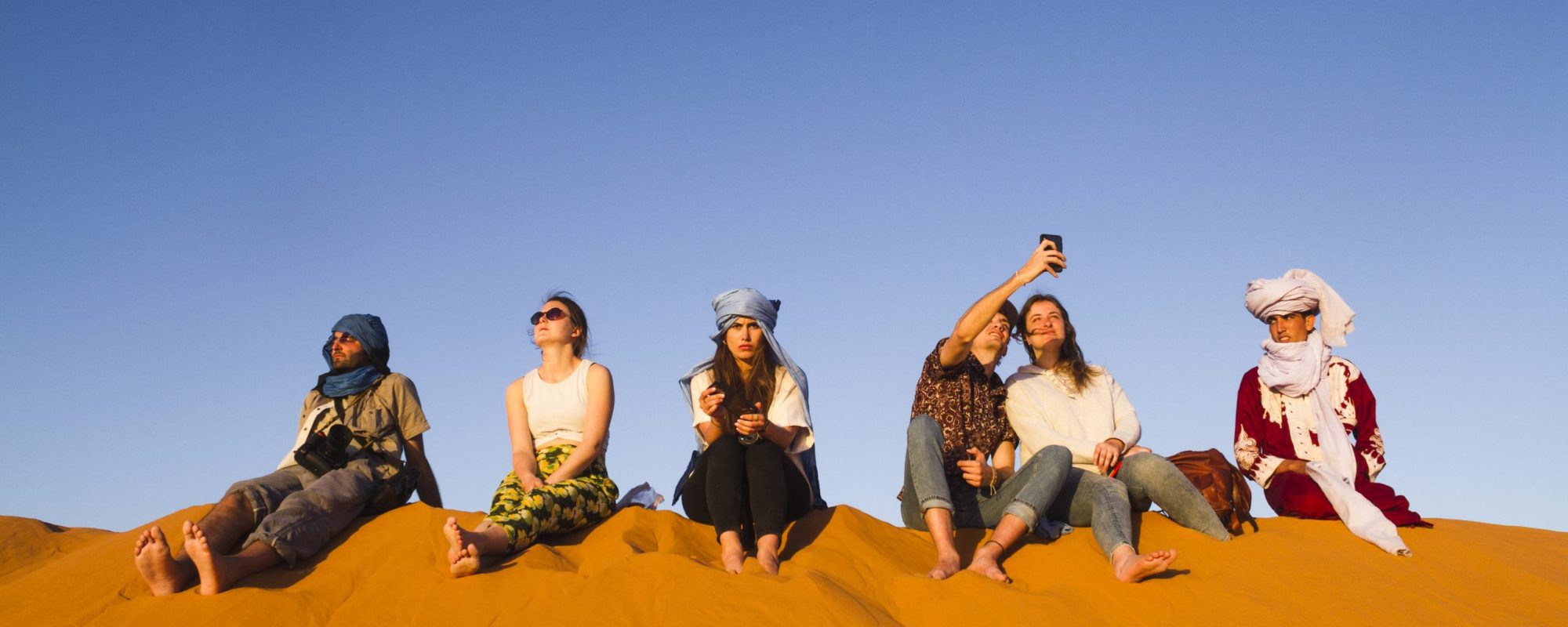 group-people-sitting-top-dune